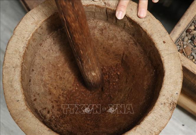 Sau khi rang, cà phê được giã thủ công bằng cối giã gạo để giữ trọn vẹn tinh dầu và hương vị mộc mạc nhất. Ảnh: Tuấn Anh - TTXVN