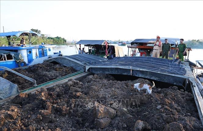 Đội Cảnh sát đường thủy số 2 (Phòng Cảnh sát giao thông Công an tỉnh An Giang) phối hợp Công an xã Bình Hoà kiểm tra số khoáng sản trên các sà lan. Ảnh: TTXVN phát
