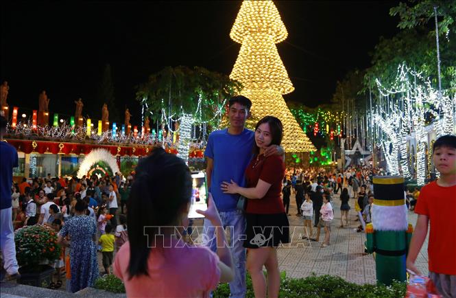 Đông du khách tham quan, chụp hình kỷ niệm bên cây thông độc đáo tại Nhà thờ Hà Phát, tỉnh Đồng Nai. Ảnh: Lê Xuân-TTXVN