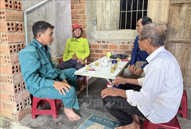 Người dân trong xóm Đội 7, thôn Phú Hữu, xã Hòa Thịnh đến thăm hỏi, cảm ơn anh Trần Công Thành (trái). Ảnh: Tường Quân - TTXVN