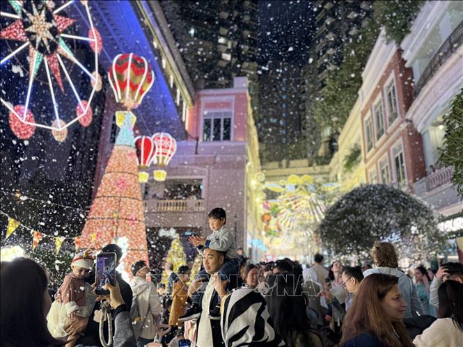 Người dân và du khách đến chụp ảnh với tuyết nhân tạo trên phố Lee Tung. Ảnh: Mạc Luyện - PV TTXVN tại Hong Kong (Trung Quốc)