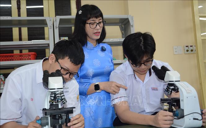 Cô Nguyễn Thị Diệu Hạnh hướng dẫn đội tuyển học sinh giỏi sinh thực hành. Ảnh: Văn Dũng-TTXVN