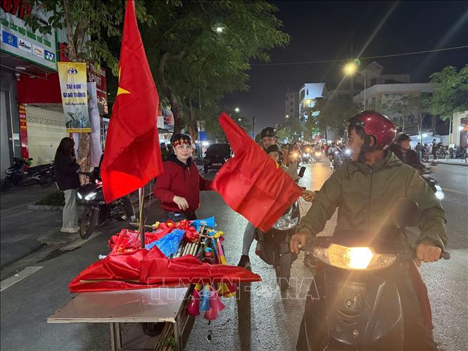 Nhiều gia đình cũng đã bán cờ, băng zôn, kèn,..để cổ vũ người hâm mộ. Ảnh Tiến Vĩnh – TTXVN