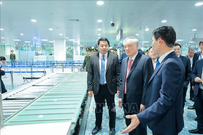 Lãnh đạo ACV giới thiệu với Phó Thủ tướng Thường trực Nguyễn Hòa Bình về hệ thống băng chuyền hành lý ứng dụng công nghệ hiện đại trong phục vụ hành khách. Ảnh: Lê Đông - TTXVN