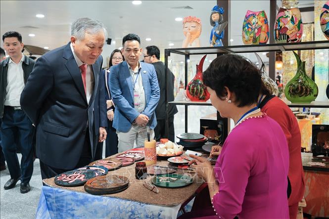 Phó Thủ tướng Thường trực Nguyễn Hòa Bình tham quan, tìm hiểu quy trình chế tác sản phẩm thủ công mỹ nghệ truyền thống tại Nhà ga hành khách T2 Cảng hàng không Quốc tế Nội Bài. Ảnh: Lê Đông - TTXVN