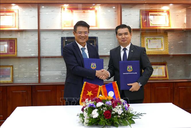 Viện trưởng Viện Kiểm sát nhân dân tối cao hai nước Việt Nam - Lào trao đổi văn kiện hợp tác. Ảnh: Xuân Tú - PV TTXVN tại Lào