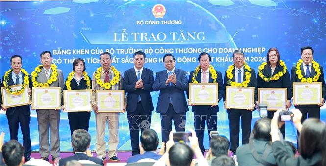 Thủ tướng Phạm Minh Chính và Bộ trưởng Bộ Công thương Nguyễn Hồng Diên trao hoa và khen thưởng cho các doanh nghiệp có thành tích xuất sắc. Ảnh: Dương Giang-TTXVN 
