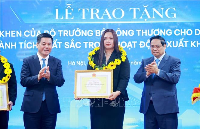 Thủ tướng Phạm Minh Chính và Bộ trưởng Bộ Công thương Nguyễn Hồng Diên trao hoa và khen thưởng cho các doanh nghiệp có thành tích xuất sắc. Ảnh: Dương Giang-TTXVN 
