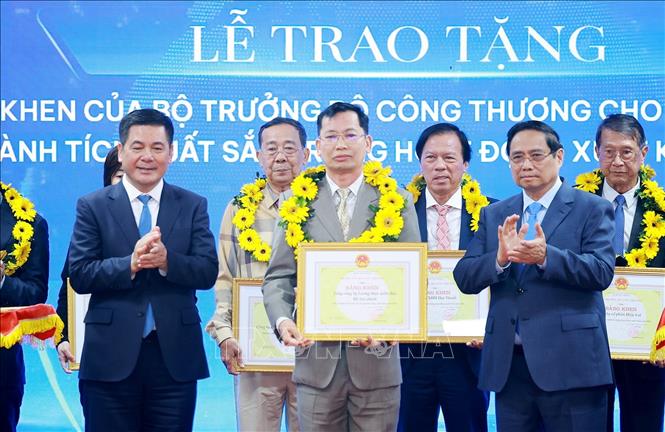 Thủ tướng Phạm Minh Chính và Bộ trưởng Bộ Công thương Nguyễn Hồng Diên trao hoa và khen thưởng cho các doanh nghiệp có thành tích xuất sắc. Ảnh: Dương Giang-TTXVN 
