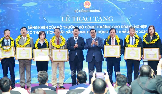Thủ tướng Phạm Minh Chính và Bộ trưởng Bộ Công thương Nguyễn Hồng Diên trao hoa và khen thưởng cho các doanh nghiệp có thành tích xuất sắc. Ảnh: Dương Giang-TTXVN 
