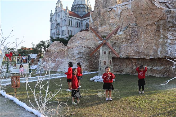 Trẻ em vui đùa, tận hưởng không khí giáng sinh tại khuôn viên Nhà thờ giáo xứ Văn Hạnh. Ảnh: Hoàng Ngà - TTXVN