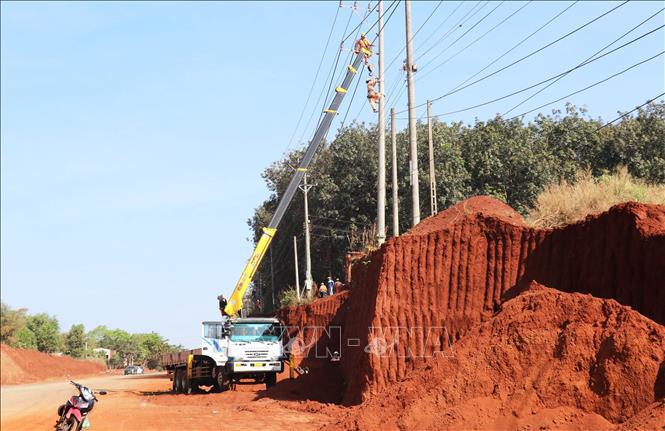 Cán bộ, công nhân điện lực Đồng Nai tiến hành di dời hơn 30 trụ điện phục vụ mở rộng tuyến đường ĐT.753. Ảnh: Đậu Tất Thành – TTXVN.