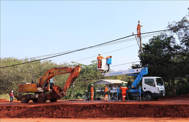 Cán bộ, công nhân điện lực Đồng Nai tiến hành di dời hơn 30 trụ điện phục vụ mở rộng tuyến đường ĐT.753. Ảnh: Đậu Tất Thành – TTXVN.