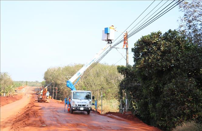 Cán bộ, công nhân điện lực Đồng Nai tiến hành di dời hơn 30 trụ điện phục vụ mở rộng tuyến đường ĐT.753. Ảnh: Đậu Tất Thành – TTXVN.
