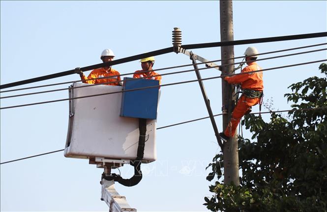 Cán bộ, công nhân điện lực Đồng Nai tiến hành di dời hơn 30 trụ điện phục vụ mở rộng tuyến đường ĐT.753. Ảnh: Đậu Tất Thành – TTXVN.