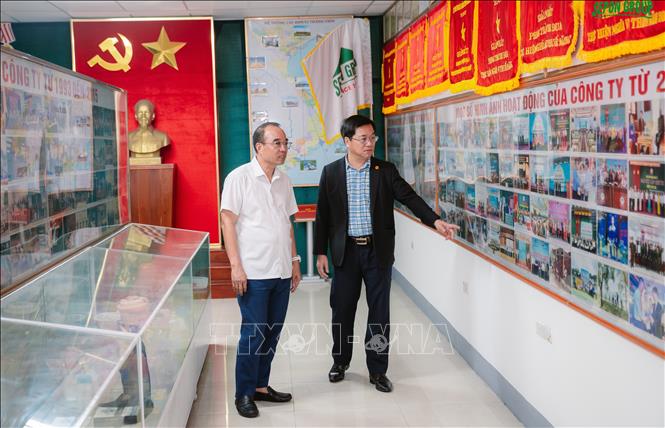 Anh Hồ Xuân Hiếu (bìa phải áo đen) giới thiệu về quá trình xây dựng và phát triển của công ty. Ảnh: Thanh Thuỷ-TTXVN