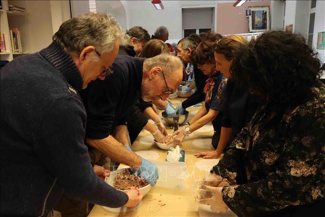The participants learn the stages of making Vietnamese traditional spring rolls. VNA Photo