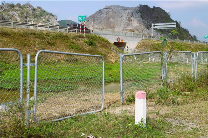 Người dân tự ý tháo dỡ hàng rào chắn của hành lang bảo vệ tuyến cao tốc để vào khu vực trồng rau muống. Ảnh: Xuân Tiến - TTXVN 