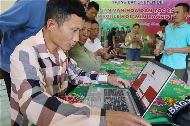 Bí thư chi bộ Lý Văn Chém hướng dẫn đảng viên cài đặt Sổ tay đảng viên điện tử tại bản Táng Ngá, xã Mường Mô. Ảnh: Nguyễn Oanh-TTXVN
