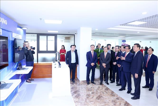 Thủ tướng Chính phủ Phạm Minh Chính và các đại biểu thăm quan hệ thống chuyển đổi số của Bppj Xây dựng. Ảnh: Quốc Khánh - TTXVN