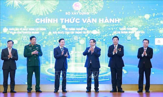 Thủ tướng Phạm Minh Chính và các đại biểu thực hiện nghi thức công bố vận hành các hệ thống công nghệ thông tin của Bộ Xây dựng. Ảnh: Dương Giang-TTXVN

