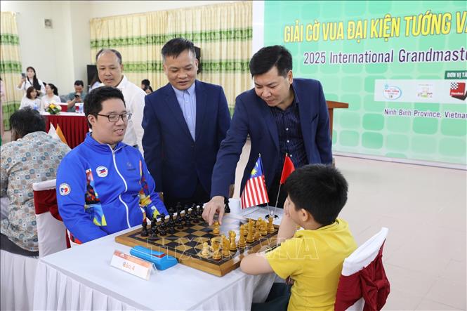 Đại diện Ban Tổ chức thực hiện nghi thức đi nước cờ đầu tiên của giải đấu. Ảnh: Đức Phương - TTXVN