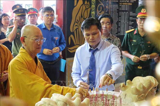 Các đại biểu dâng hương tưởng nhớ các anh hùng liệt sĩ tại Nghĩa trang liệt sĩ Vĩnh Hưng - Tân Hưng. Ảnh: Bùi Giang – TTXVN
