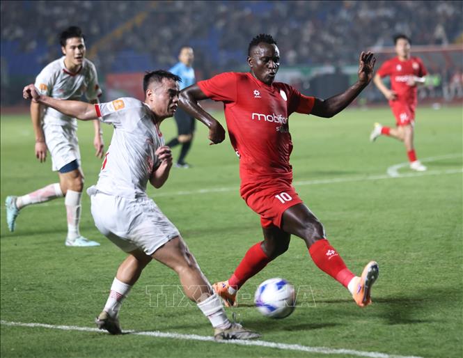 Một pha bóng trong trận đấu giữa CLB PVF Công an nhân dân (áo đỏ) và CLB Thể Công Viettel (áo trắng). Ảnh: Thanh Tùng - TTXVN