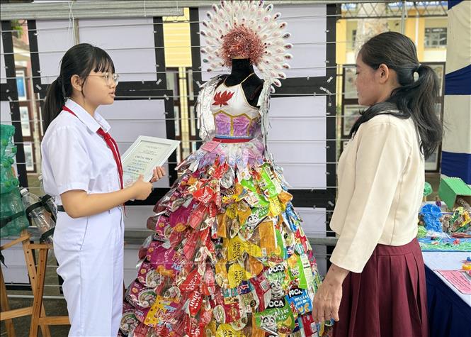 Em Đoàn Ngô Hà Linh (lớp 8C, Trường THCS Nguyễn Hữu Thọ) giới thiệu sản phẩm đạt giải Ba tại Hội thi tái chế rác thải nhựa. Ảnh: Tường Quân - TTXVN