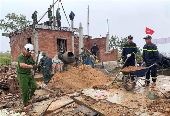 Cán bộ, chiến sĩ Công an tỉnh Đắk Lắk phối hợp với lực lượng tại địa phương xây dựng nhà ở cho người dân vùng lũ. Ảnh: Tường Quân - TTXVN