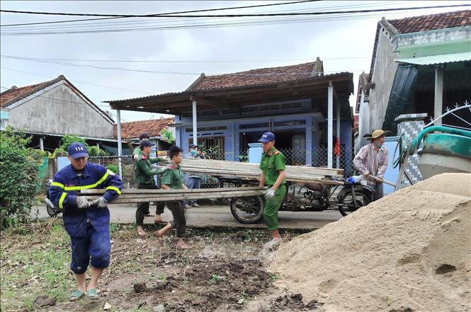 Chiến sĩ Công an tỉnh Đắk Lắk hỗ trợ vận chuyển vật liệu xây dựng đến xây nhà cho người dân phường Đông Hòa. Ảnh: Tường Quân - TTXVN