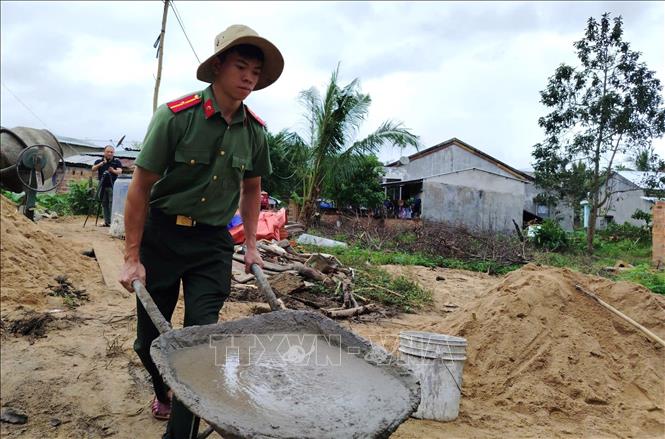 Chiến sỹ Công an xã Xuân Lãnh vượt khó khăn giúp người dân xây dựng nhà ở. Ảnh: Tường Quân - TTXVN