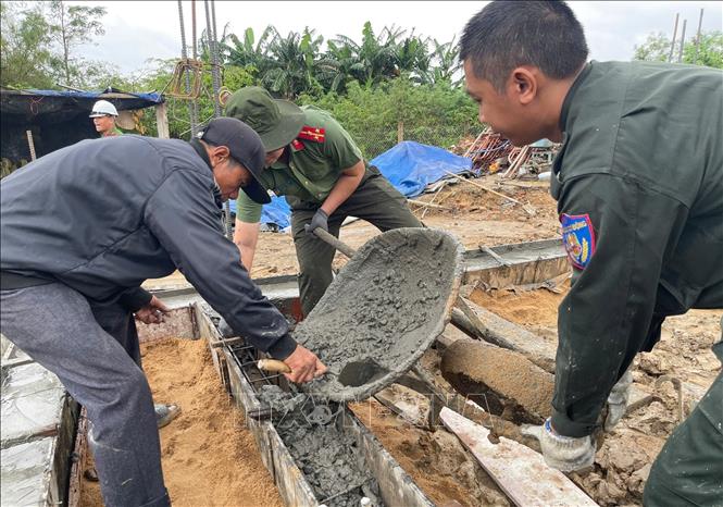 Công an tỉnh Đắk Lắk giúp người dân vùng lũ thực hiện các phần việc quan trọng xây dựng nhà ở đảm bảo tiến độ. Ảnh: Tường Quân - TTXVN
