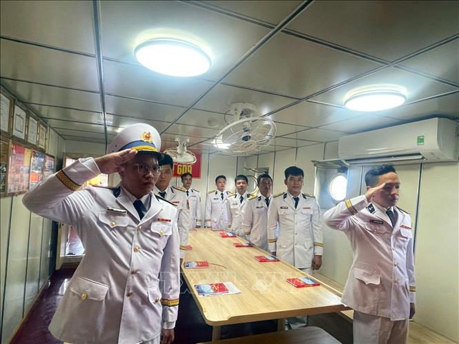 Thực hiện nghi thức chào cờ tại Lễ kết nạp Đảng trên tàu 609. Ảnh: TTXVN phát