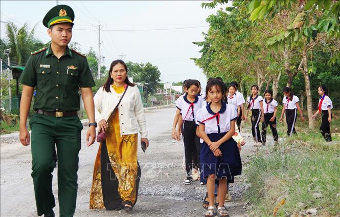 Trung úy Đặng Trường Vũ, đội trưởng Vận động quần chúng, Đồn Biên phòng cửa khẩu quốc tế Dinh Bà, hướng dẫn các học sinh tham quan đơn vị. Ảnh: TTXVN phát