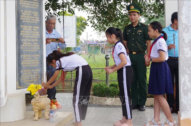 Các học sinh thắp hương tại bia tưởng niệm liệt sĩ. Ảnh: TTXVN phát