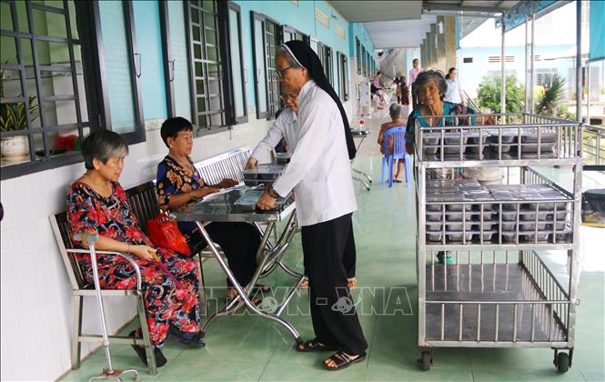Phát cơm cho người được chăm sóc tại Cơ sở Bảo trợ xã hội dưỡng lão tình thương Suối Tiên (Đồng Nai). Ảnh: Lê Xuân-TTXVN