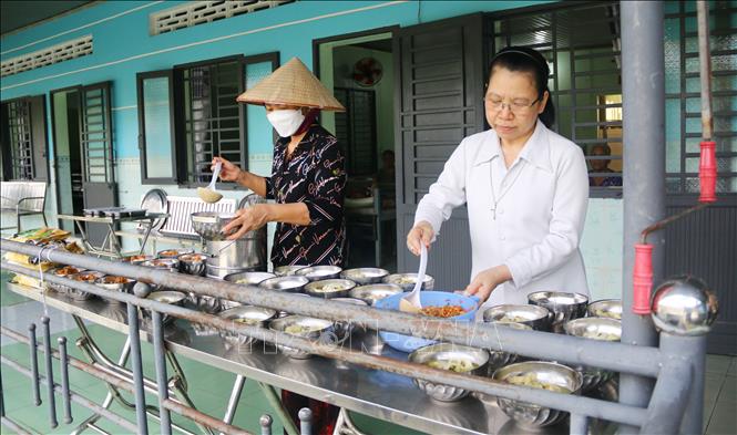 Các nữ tu tại Cơ sở Bảo trợ xã hội dưỡng lão tình thương Suối Tiên (Đồng Nai) chia cơm cho người già. Ảnh: Lê Xuân-TTXVN