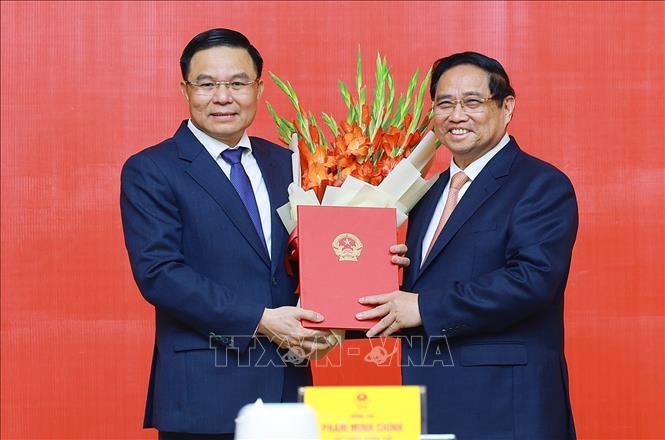 Prime Minister Pham Minh Chinh presents a decision to appointment Le Manh Hung as Acting Minister of Industry and Trade. VNA Photo: Dương Giang