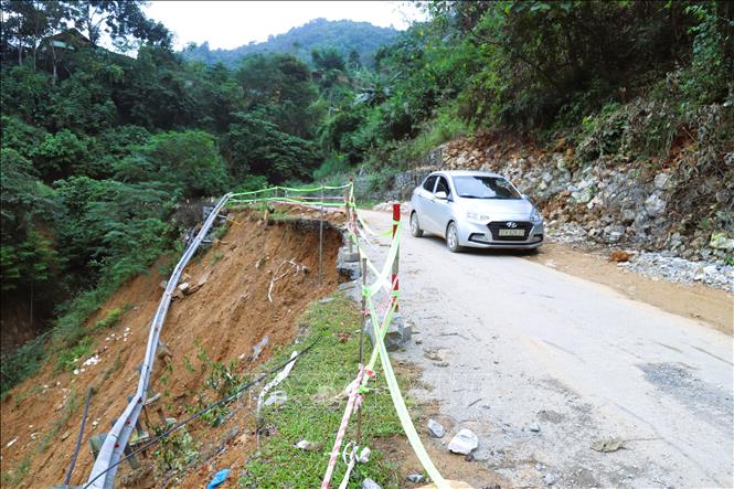 Phương tiện ô tô con đi qua những điểm sạt lở ta-luy âm kiểu “hàm ếch” phải giảm vận tốc, thận trọng di chuyển. Ảnh: Xuân Tiến - TTXVN 
