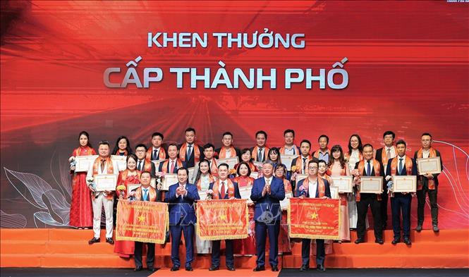 Phó Chủ tịch UBND TP Hà Nội Nguyễn Mạnh Quyền và Trưởng Ban Tuyên giáo Ủy ban Trung ương Mặt trận Tổ quốc Việt Nam Vũ Văn Tiến trao Bằng khen và Cờ thi đua cấp thành phố. Ảnh: Lê Đông - TTXVN