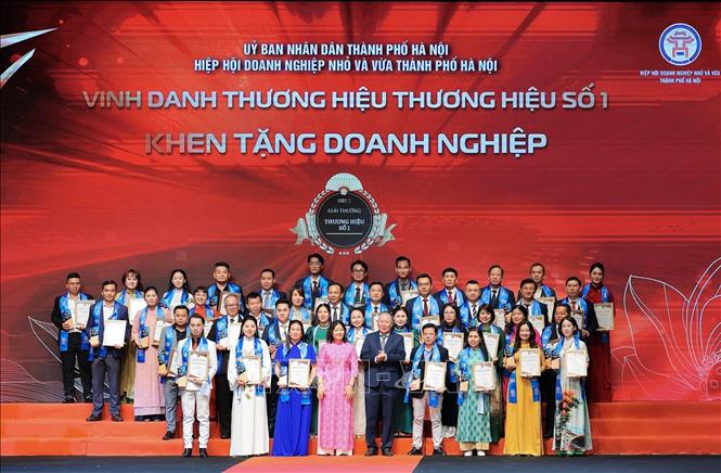 Phó Giám đốc Ngân hàng Nhà nước Chi nhánh Khu vực 1 Trần Quốc Hùng và Chủ tịch Hiệp hội các nhà bán lẻ Việt Nam Trần Thị Phương Lan trao bằng khen cho các tập thể đạt giải thưởng Thương hiệu số 01. Ảnh: Lê Đông - TTXVN