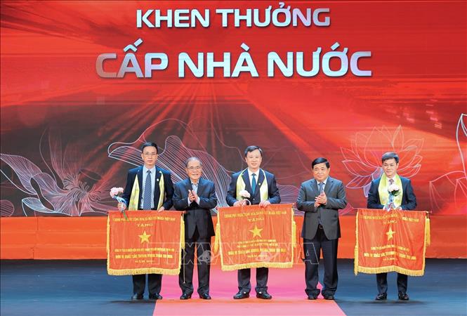 Phó Thủ tướng Nguyễn Chí Dũng và nguyên Chủ tịch Quốc hội Nguyễn Sinh Hùng trao Cờ thi đua Chính phủ cho các đơn vị có thành tích xuất sắc. Ảnh: Lê Đông - TTXVN