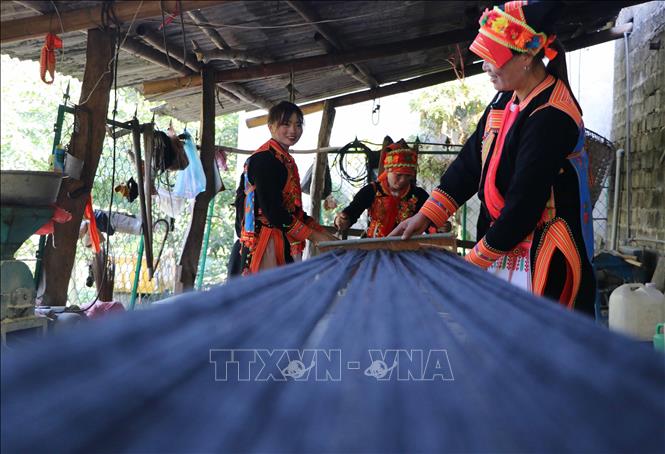 Dao women spin yarn and sew their own traditional clothing. VNA Photo: Nguyễn Oanh