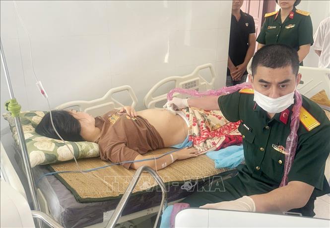 Bác sĩ Tổ Cấp cứu đường không, Bệnh viện Quân y 175 siêu âm, chẩn đoán cho thai phụ ngay tại Bệnh xá đảo Sinh Tồn. Ảnh: TTXVN phát