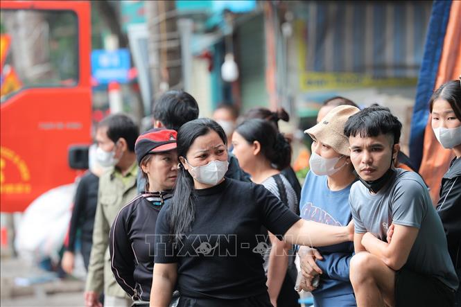 Nhiều tiểu thương động viên nhau giữa khung cảnh ngổn ngang sau vụ cháy chợ Xanh Định Công, phường Phương Liệt, Hà Nội. Ảnh: Lê Đông - TTXVN