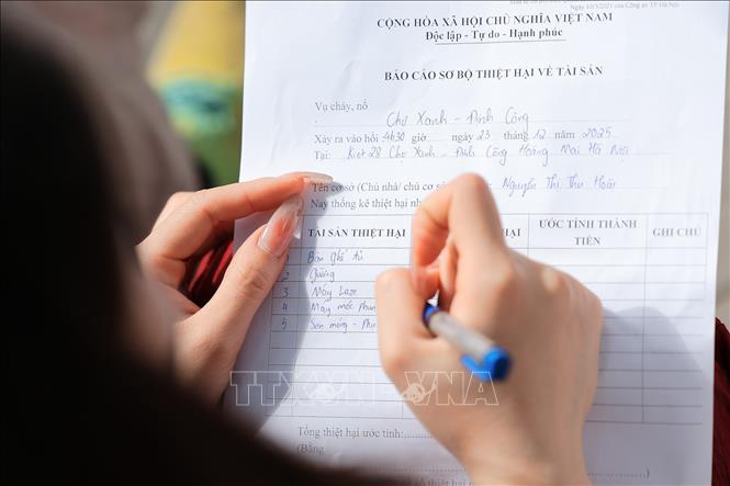 Người dân làm báo cáo thiệt hại tài sản sau vụ cháy chợ Xanh Định Công. Ảnh: Lê Đông - TTXVN