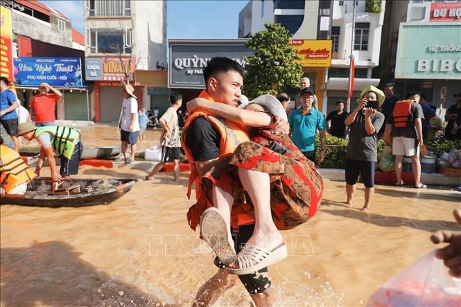  Lực lượng công an tỉnh Thái Nguyên hỗ trợ người dân vùng ngập lụt di chuyển đến khu vực an toàn. Ảnh: Minh Quyết - TTXVN