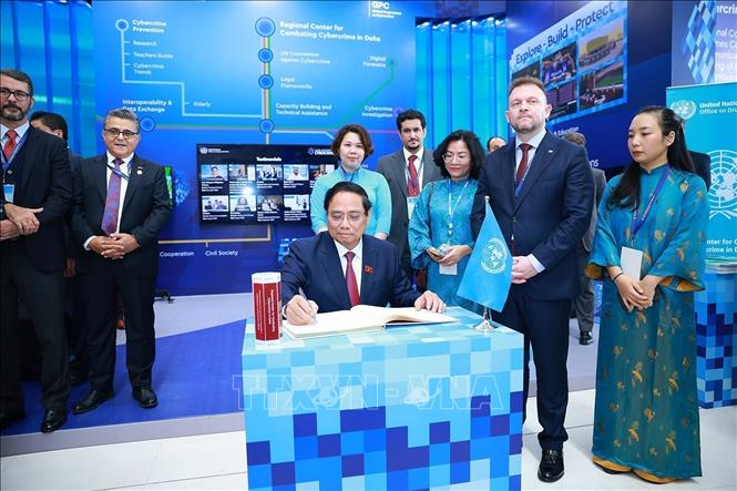 Prime Minister Pham Minh Chinh signs the guestbook after visiting the exhibition space showcasing the United Nations’ development achievements. Photo: Duong Giang – VNA