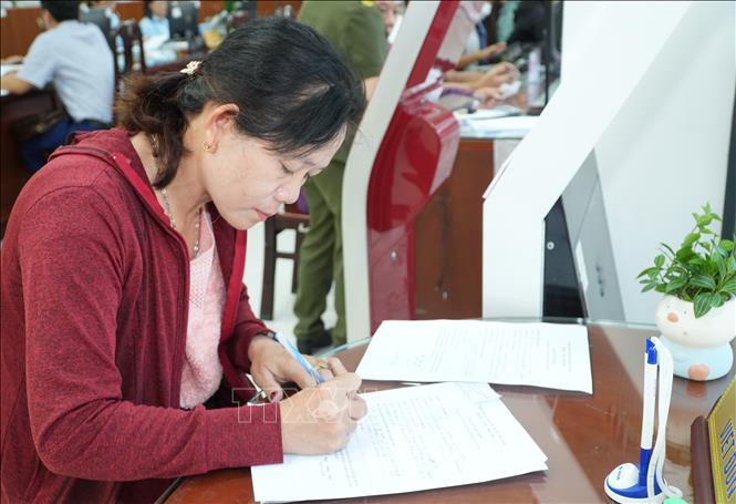 Người dân TP. Hồ Chí Minh đang dần làm quen với hồ sơ thủ tục hành chính không... giấy. Ảnh: Hữu Duyên - TTXVN